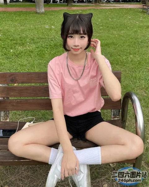 阿拉菲女孩坐在长凳上，头上戴着猫耳朵