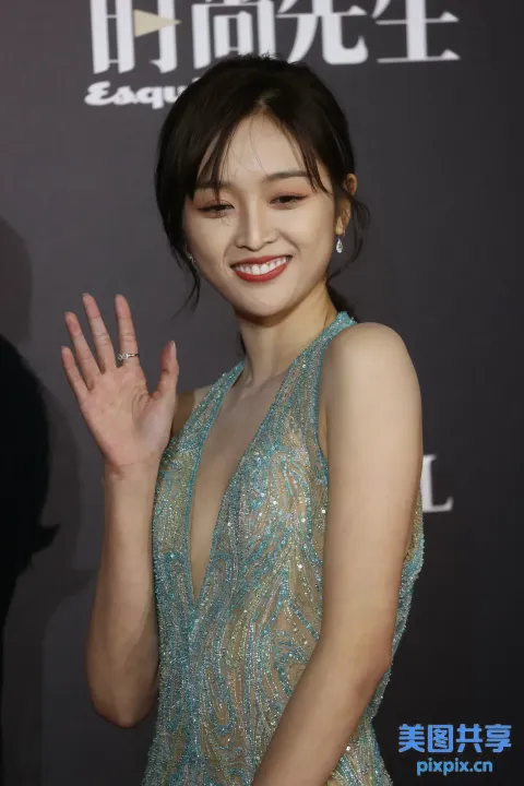 身穿蓝色连衣裙的阿拉夫亚洲女人挥手