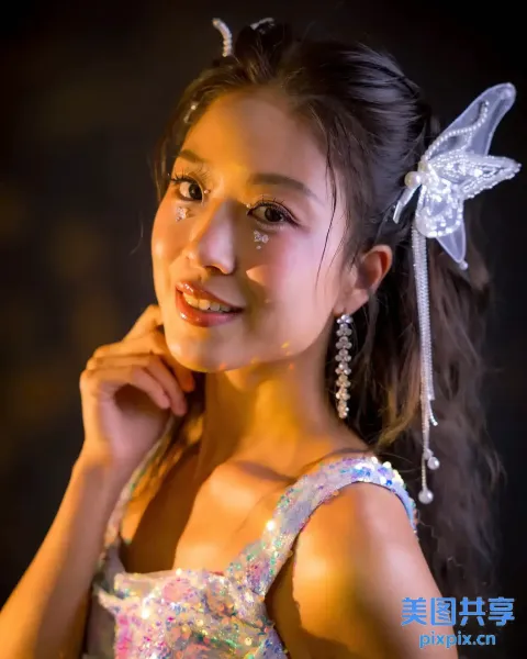 戴蝴蝶发夹和闪亮连衣裙的亚洲女孩