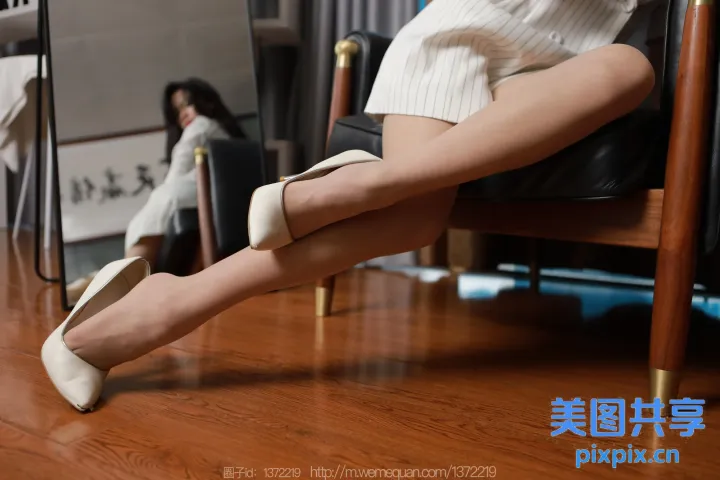 有个女人坐在椅子上，双腿交叉