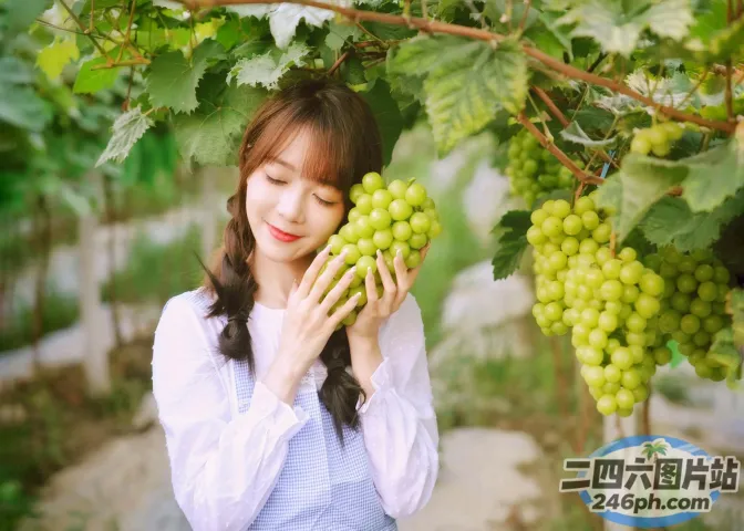阿拉菲女人手里拿着一串绿葡萄