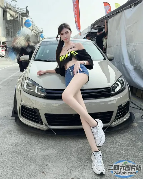 坐在停车场汽车引擎盖上的阿拉菲德女人