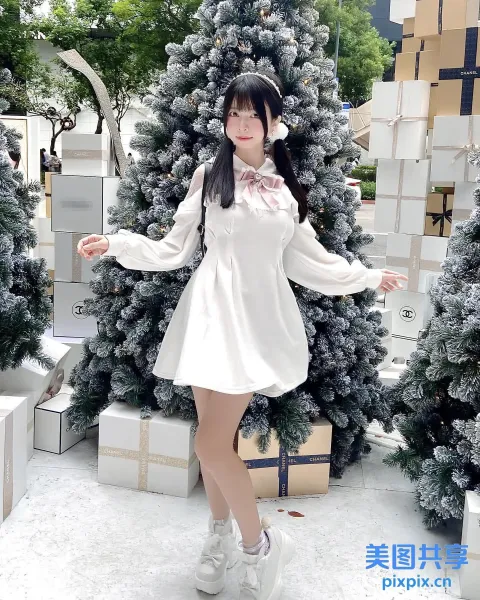There is an woman standing before a christmation tree （有个女人站在圣诞树前）