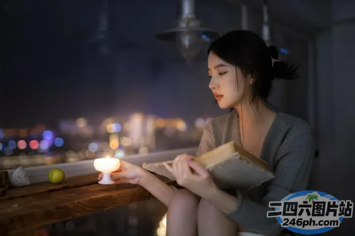 坐在阳台上看书，手里拿着蜡烛的女人
