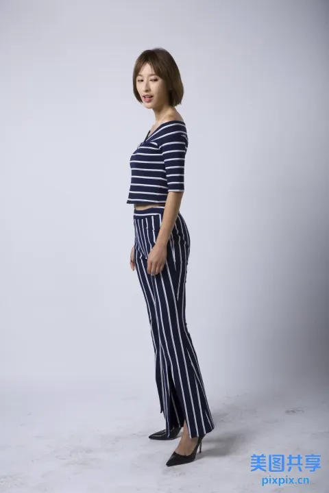 穿着条纹裤子和条纹上衣的阿拉夫女人站在工作室里