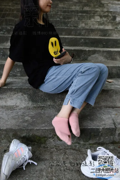 阿拉菲拿着手机坐在建筑物的台阶上