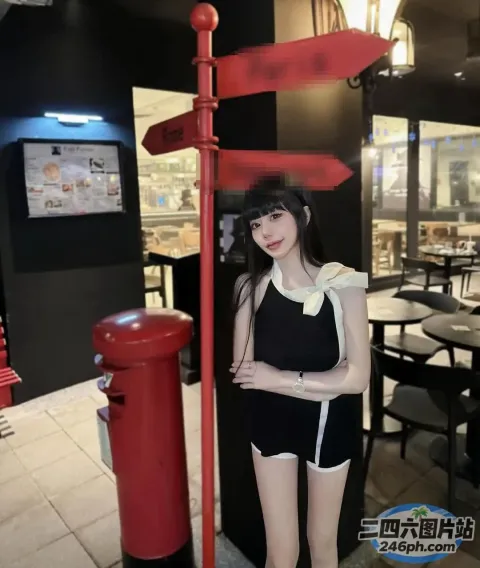 身穿黑色连衣裙的阿拉夫德女子站在一根红色杆子旁
