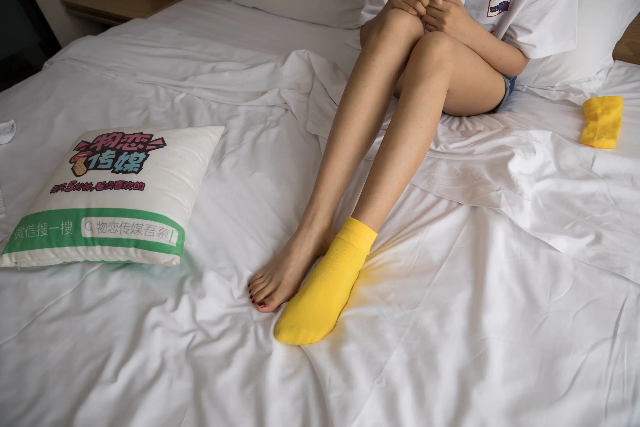 有个女人坐在床上，手里拿着一个枕头