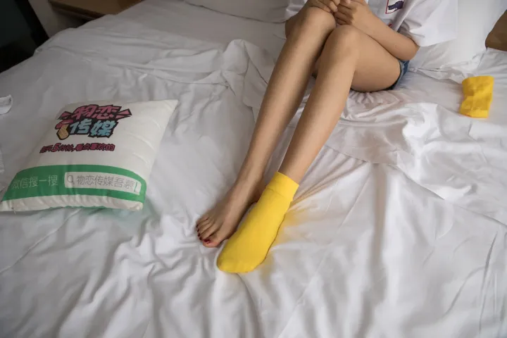 有个女人坐在床上，手里拿着一个枕头