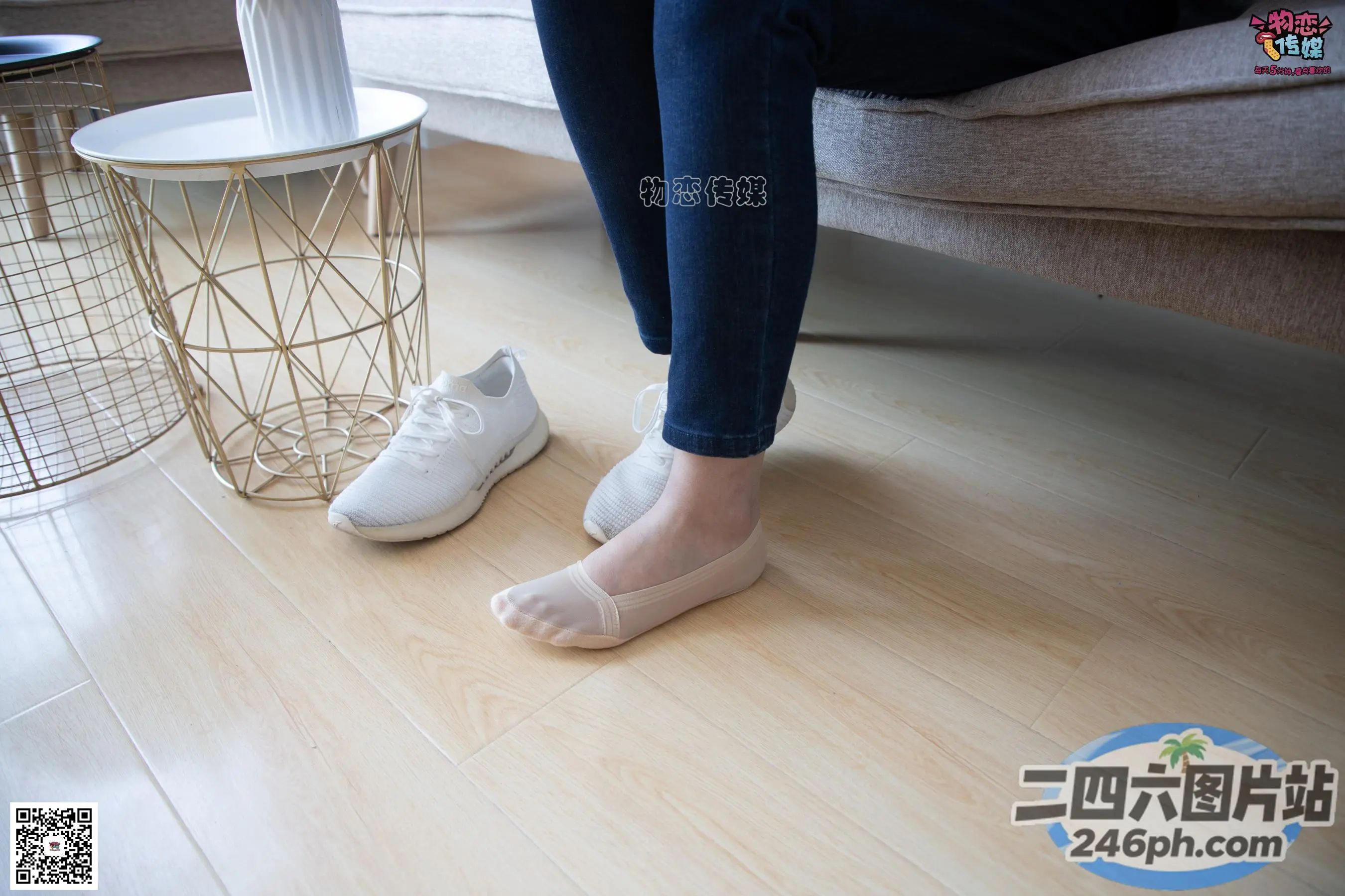 有人站在木地板上，脚放在桌子上