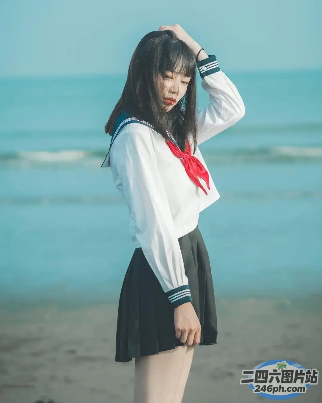 身穿水手服的 arafed 亚洲女子在海滩上摆姿势