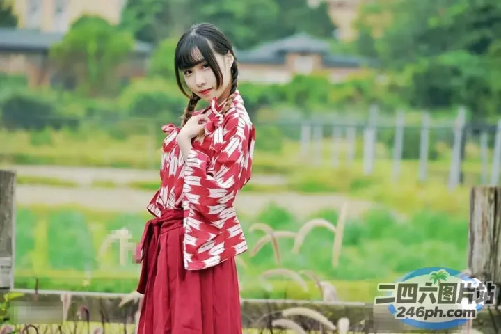 篱笆前站着一个穿着红白和服的女人