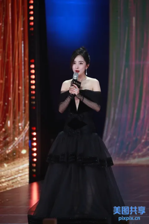身穿黑色连衣裙的阿拉夫女人在舞台上拿着麦克风