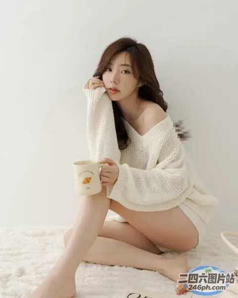 一个女人坐在床上，手里拿着一杯咖啡