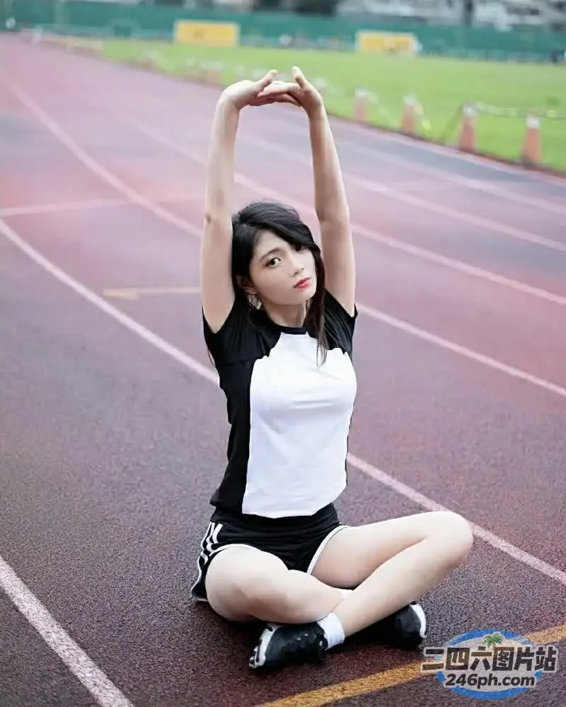 坐在跑道上的阿拉夫德女人伸展双臂