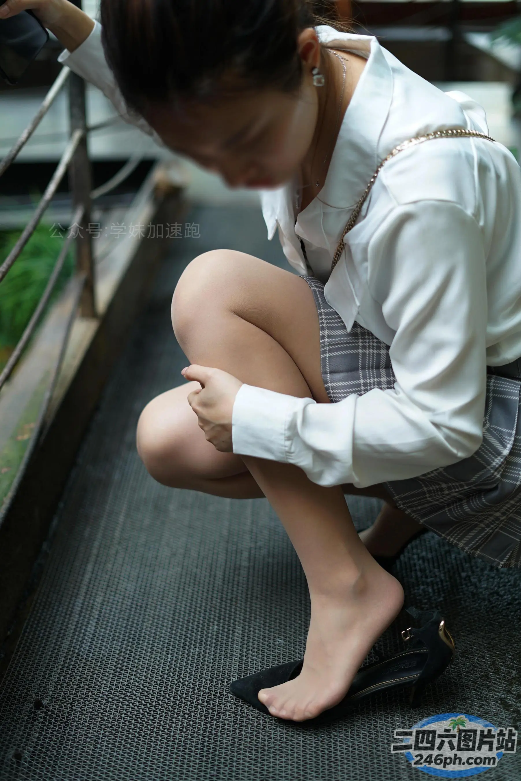 身穿校服的 arafed 亚裔妇女蹲在栏杆上