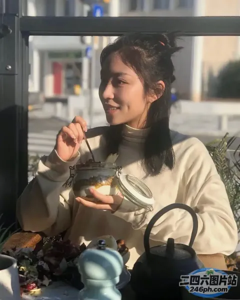 有个女人坐在桌子旁吃着一碗食物