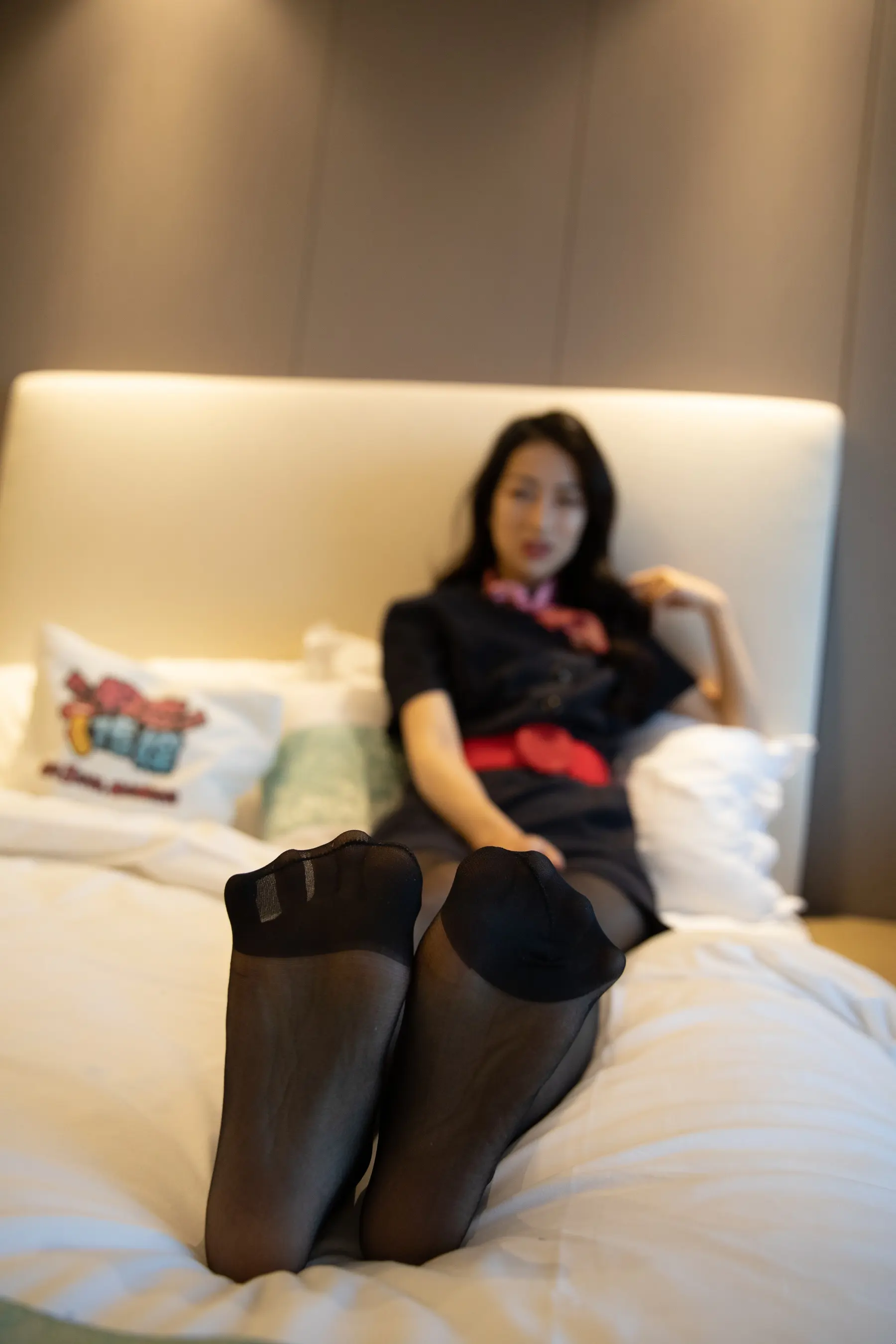 女子躺在床上，双腿抬起，双脚抬起