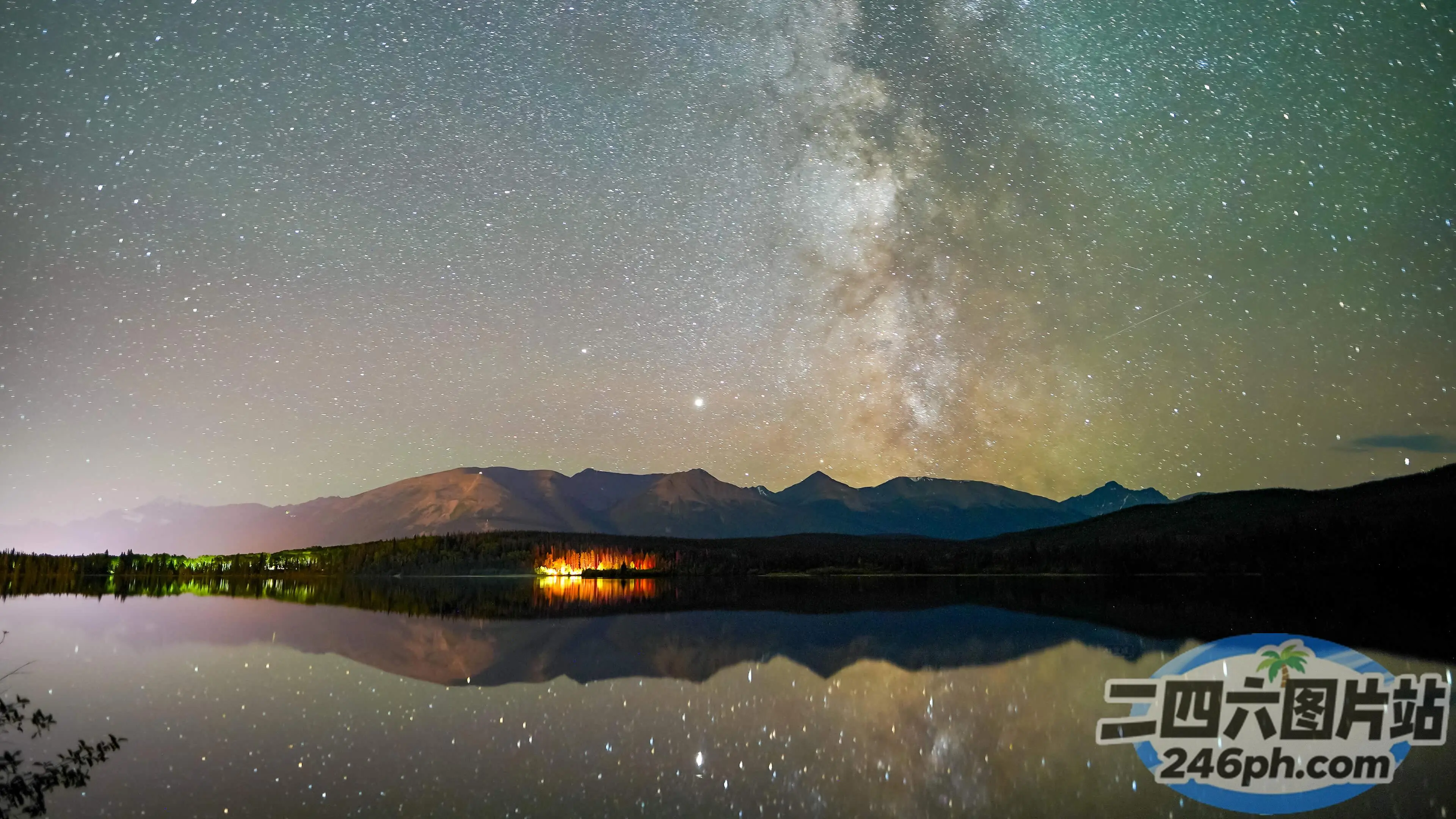 湖面上的星空，背景是露营车和一座山