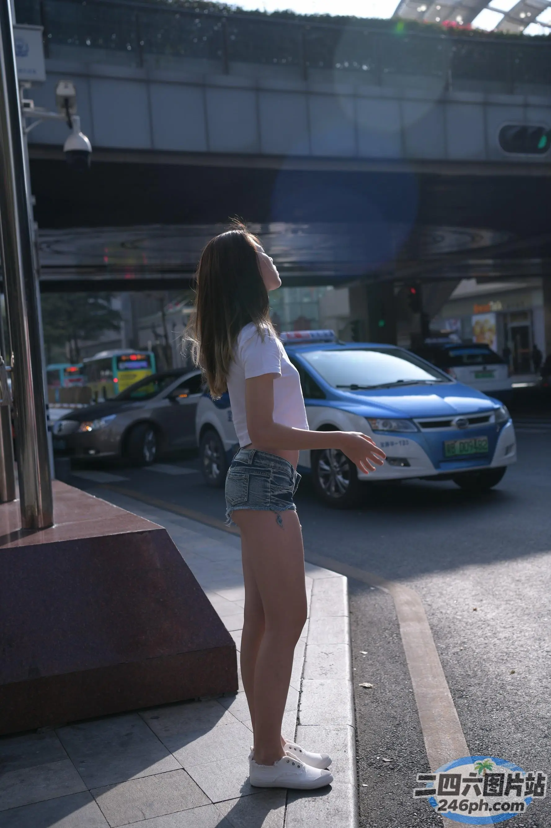 车前的人行道上站着一名女子