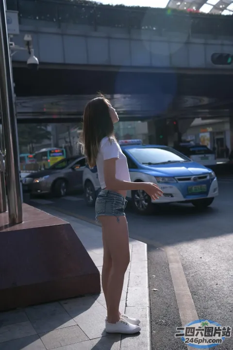 车前的人行道上站着一名女子