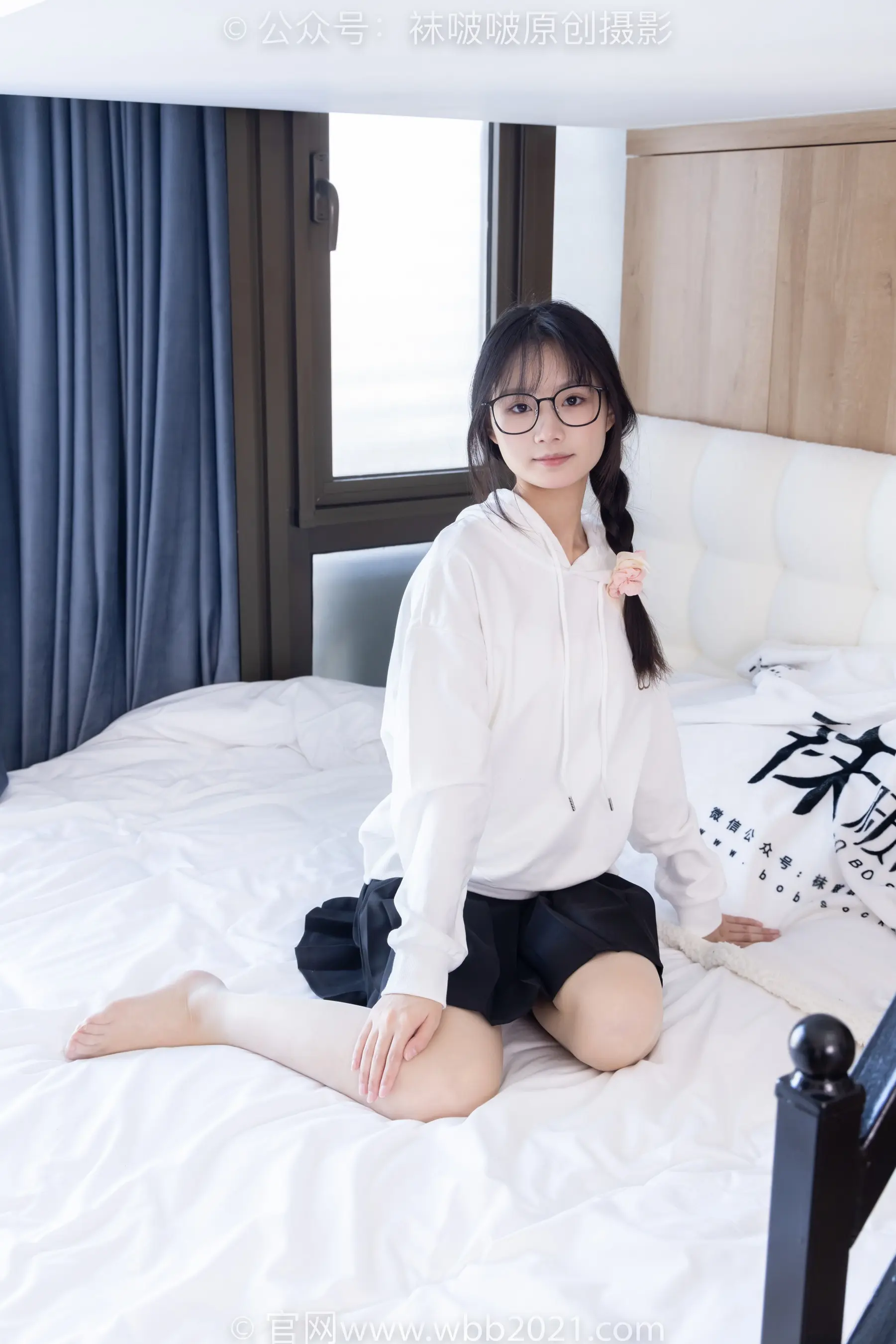 穿着白衬衫和黑色短裤坐在床上的阿拉菲德亚裔妇女