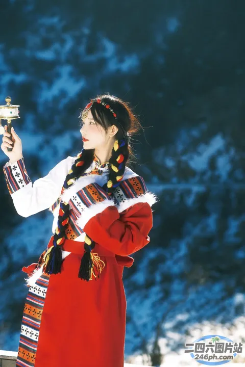红裙女子在雪山前拿着银色物体