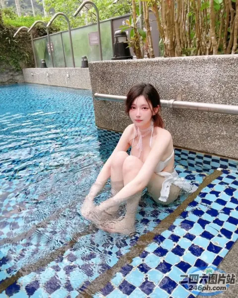 有一个女人坐在游泳池里，双腿交叉