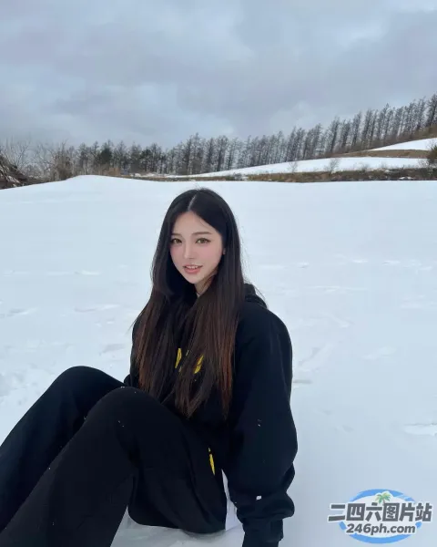 一名女子坐在雪地里，膝盖上放着滑雪板
