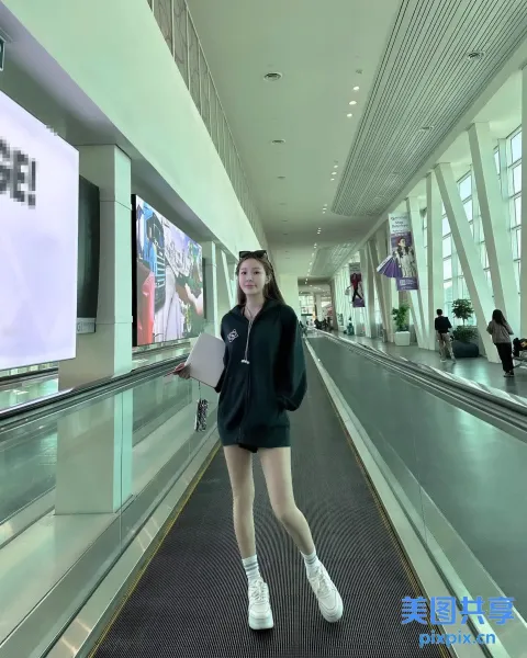 有一名女子站在建筑物的自动扶梯上
