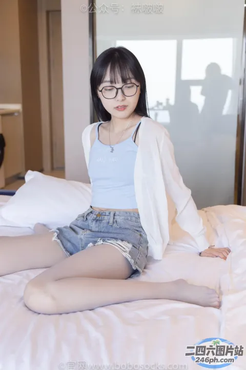坐在床上的戴眼镜的 arafed 亚洲妇女