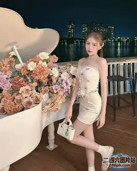 有个女人站在一架插着鲜花的三角钢琴旁边