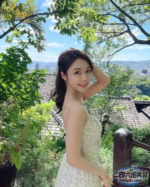 一个穿着白色连衣裙的女人站在一棵树前