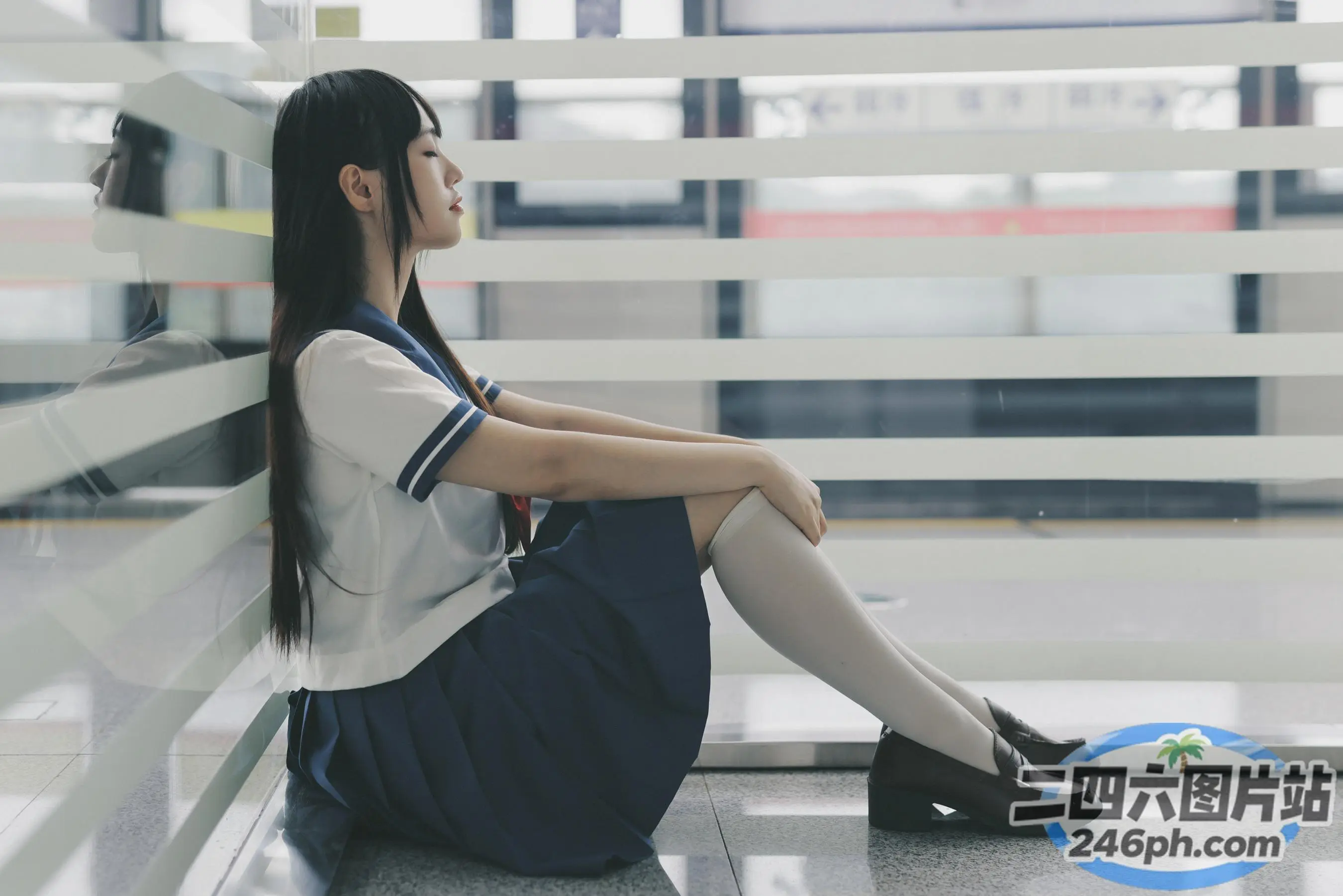 阿拉菲穿着校服坐在地板上，手里拿着香烟