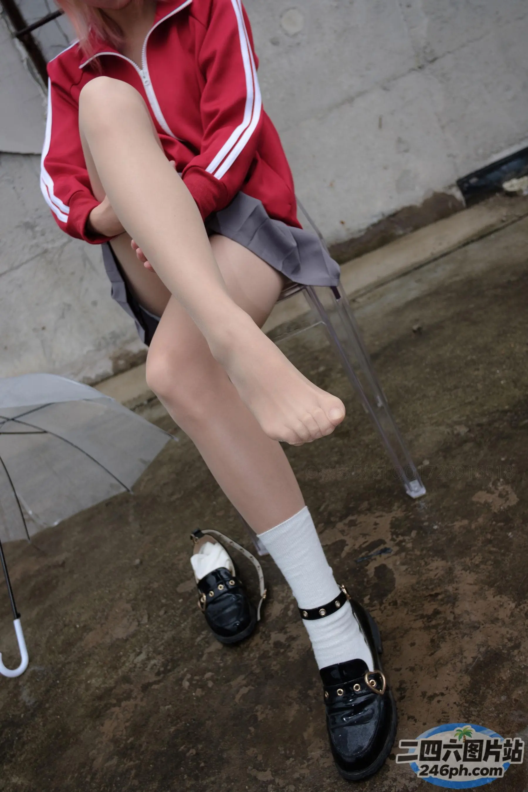 有一个女人坐在椅子上，撑着伞
