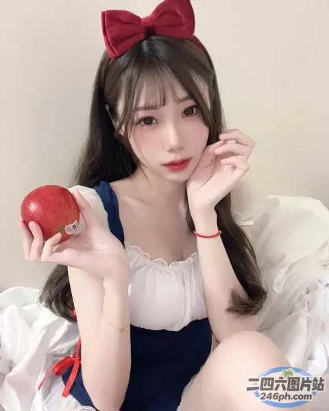 床上坐着一个女人，手里拿着一个苹果