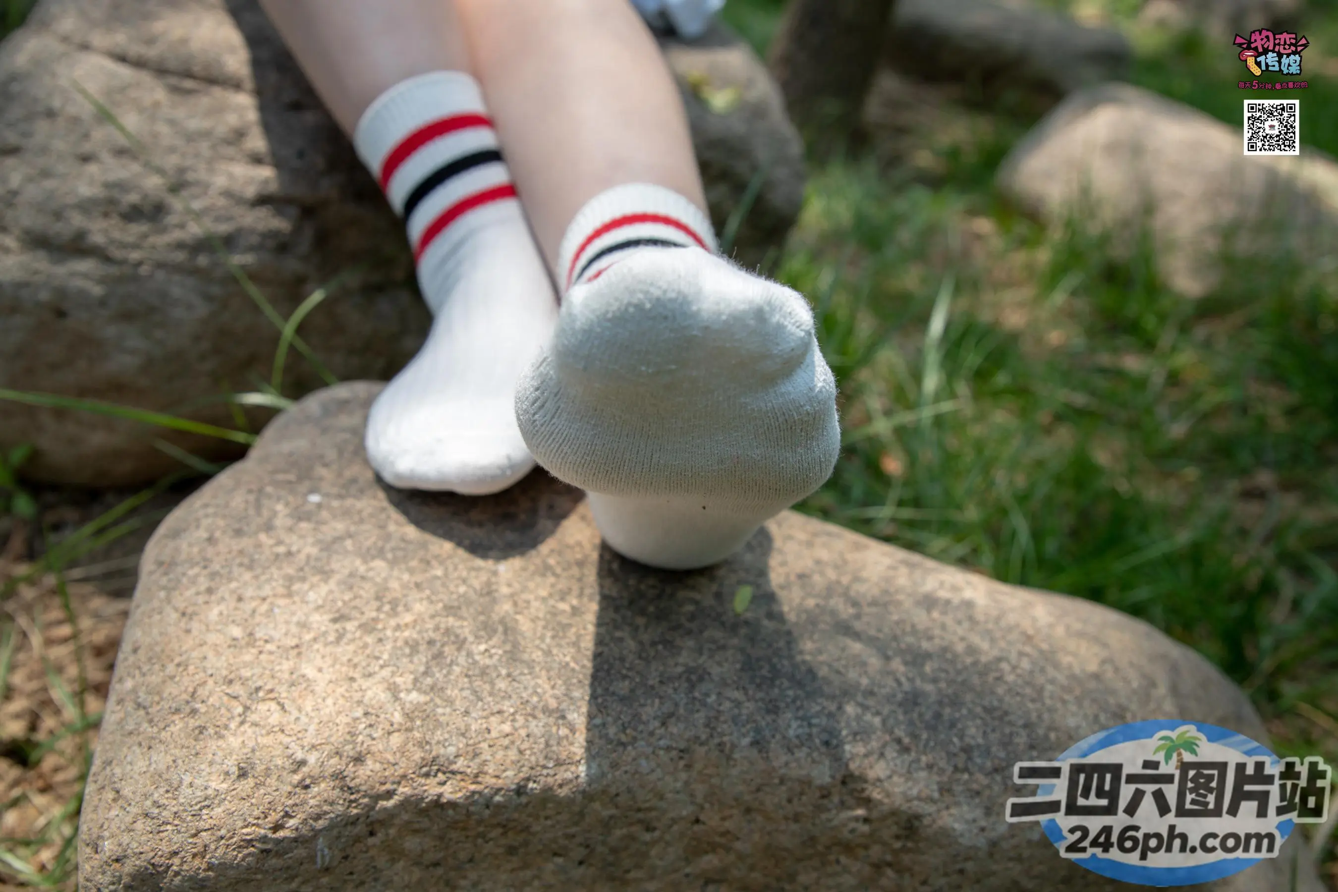 一个人坐在岩石上，穿着一双袜子的 arafed 腿