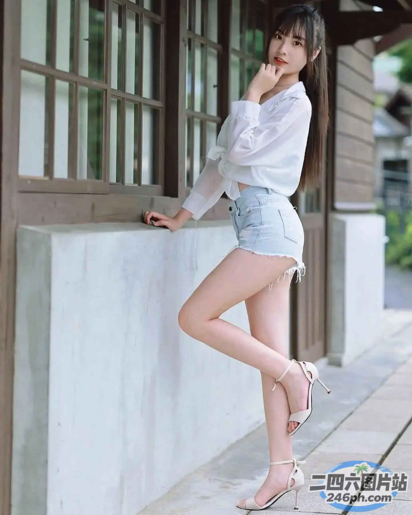阿拉伯裔亚洲妇女双腿交叉靠在墙上