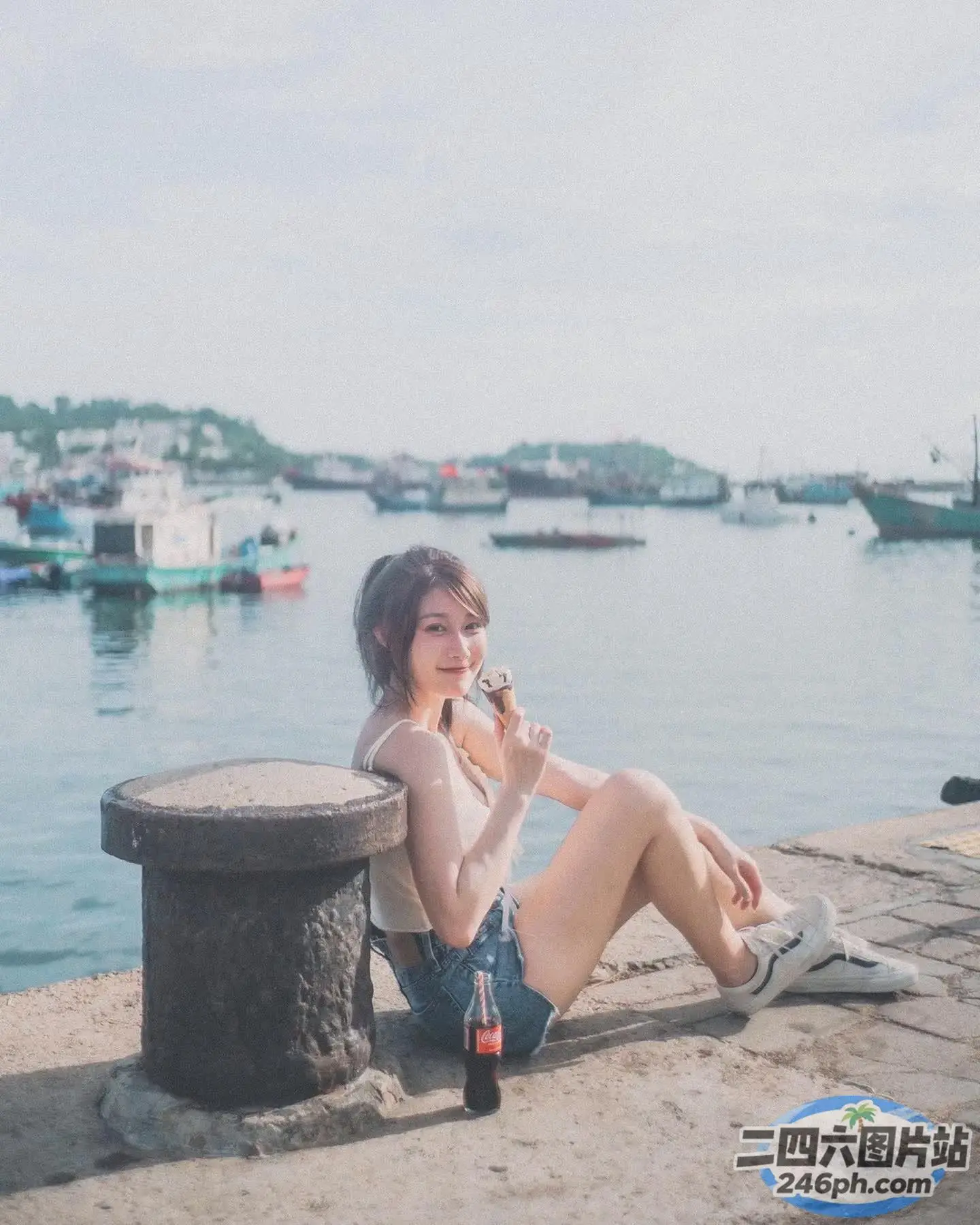有一个女人坐在混凝土长凳上吃一块披萨