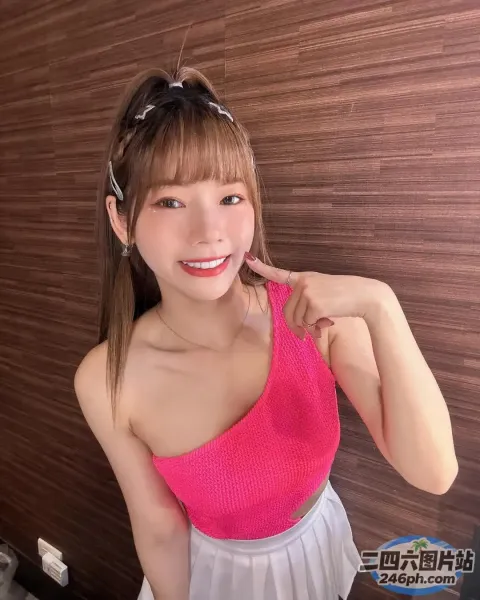 一位身穿粉红色上衣的女子摆姿势拍照的特写