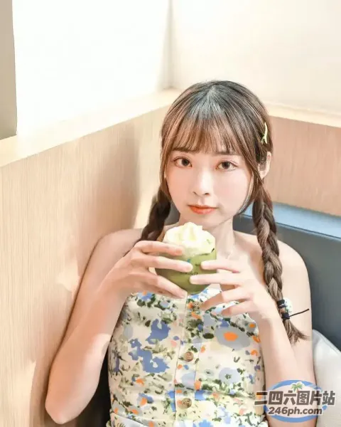 穿着碎花裙的 Araffe 女孩吃着纸杯蛋糕
