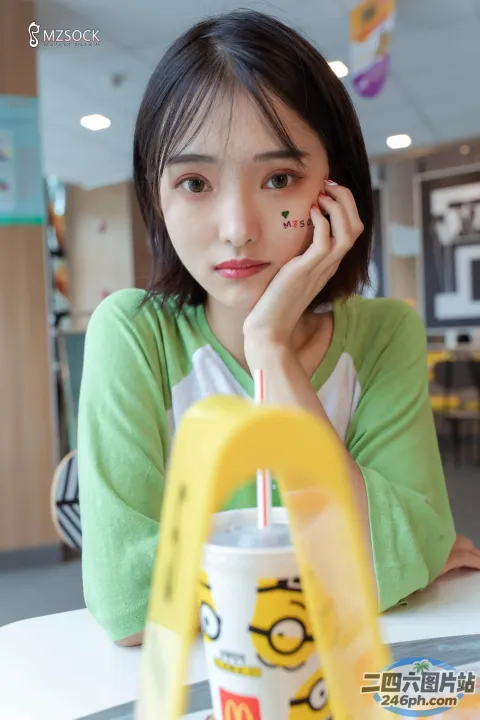 阿拉夫德女人坐在桌子旁，手里拿着饮料和吸管