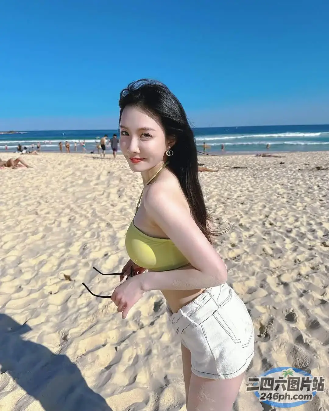 海滩上穿着黄色上衣和白色短裤的 Araffed 女人