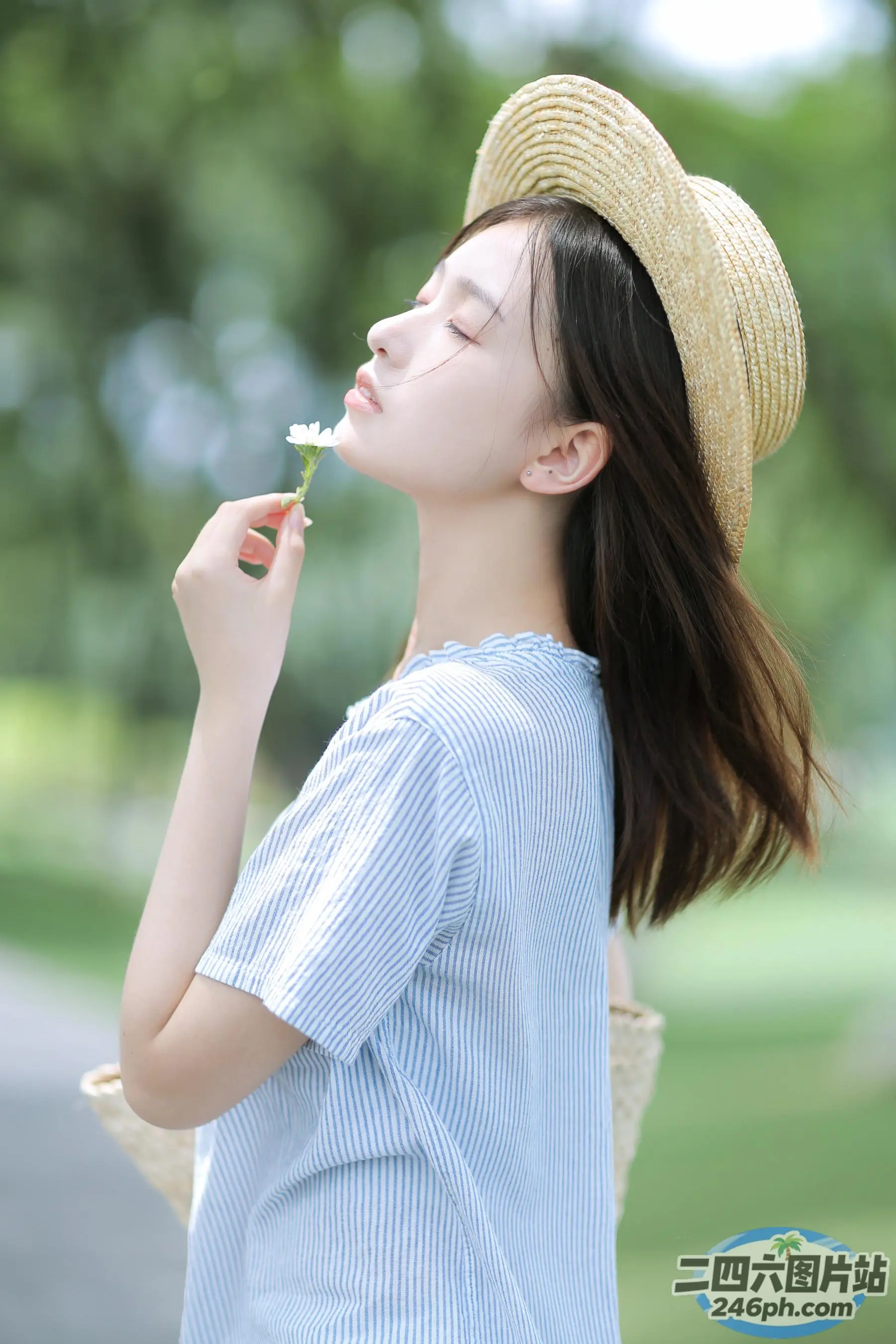 戴帽子的 Araffe 女人在公园里吹花