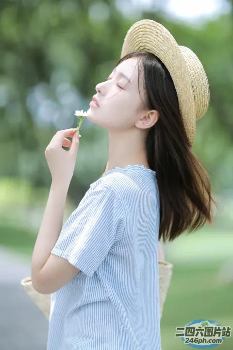 戴帽子的 Araffe 女人在公园里吹花