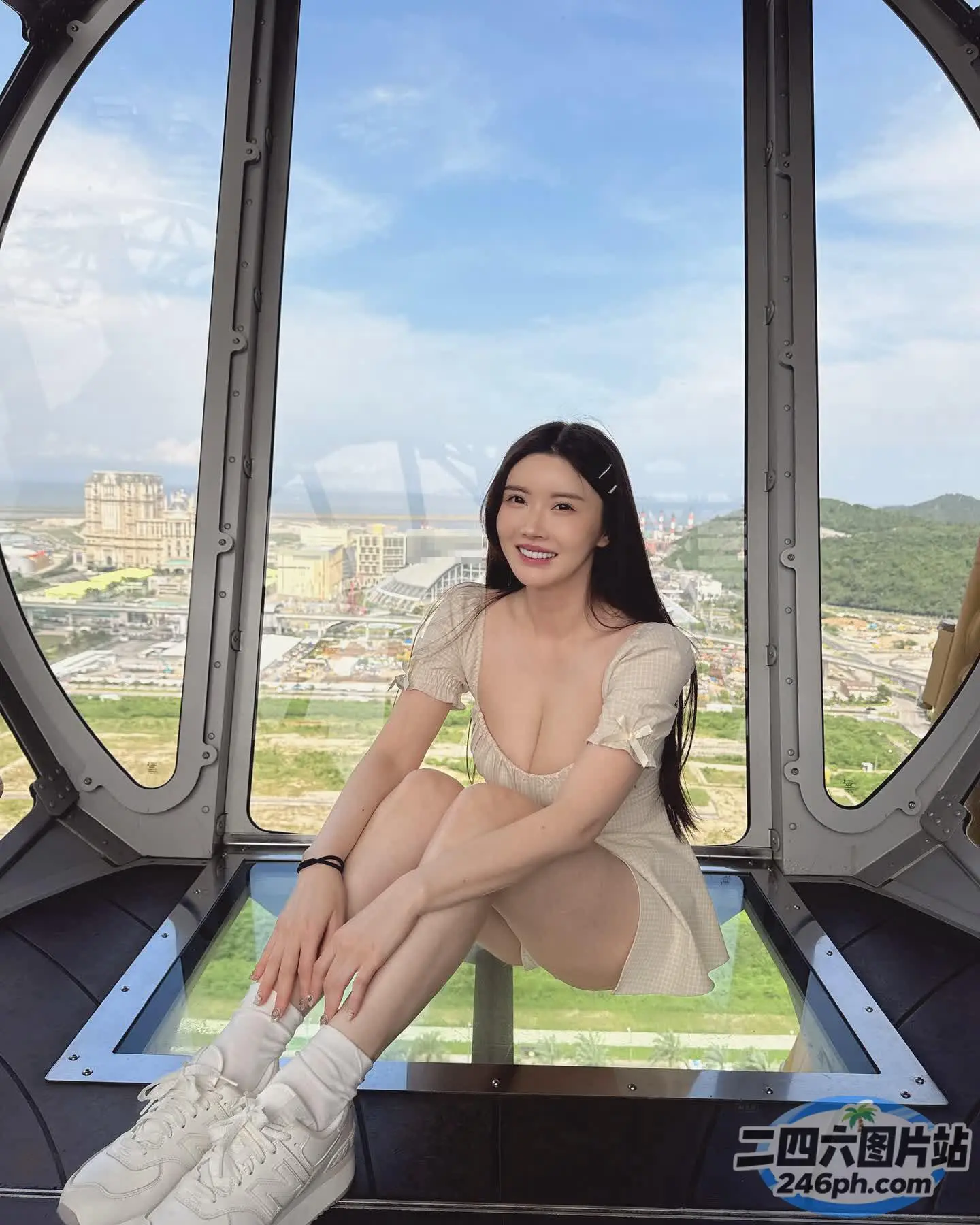 一名女子坐在建筑物的玻璃平台上