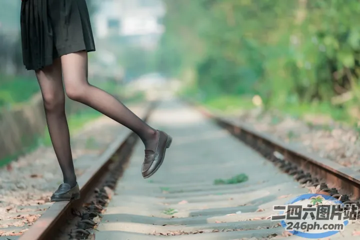 有个女人抬起双腿走在火车轨道上