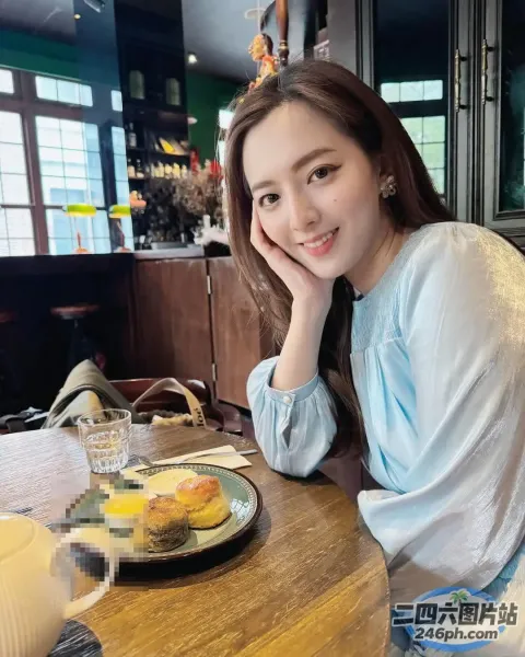 阿拉菲女人坐在桌子旁，手里拿着一盘食物