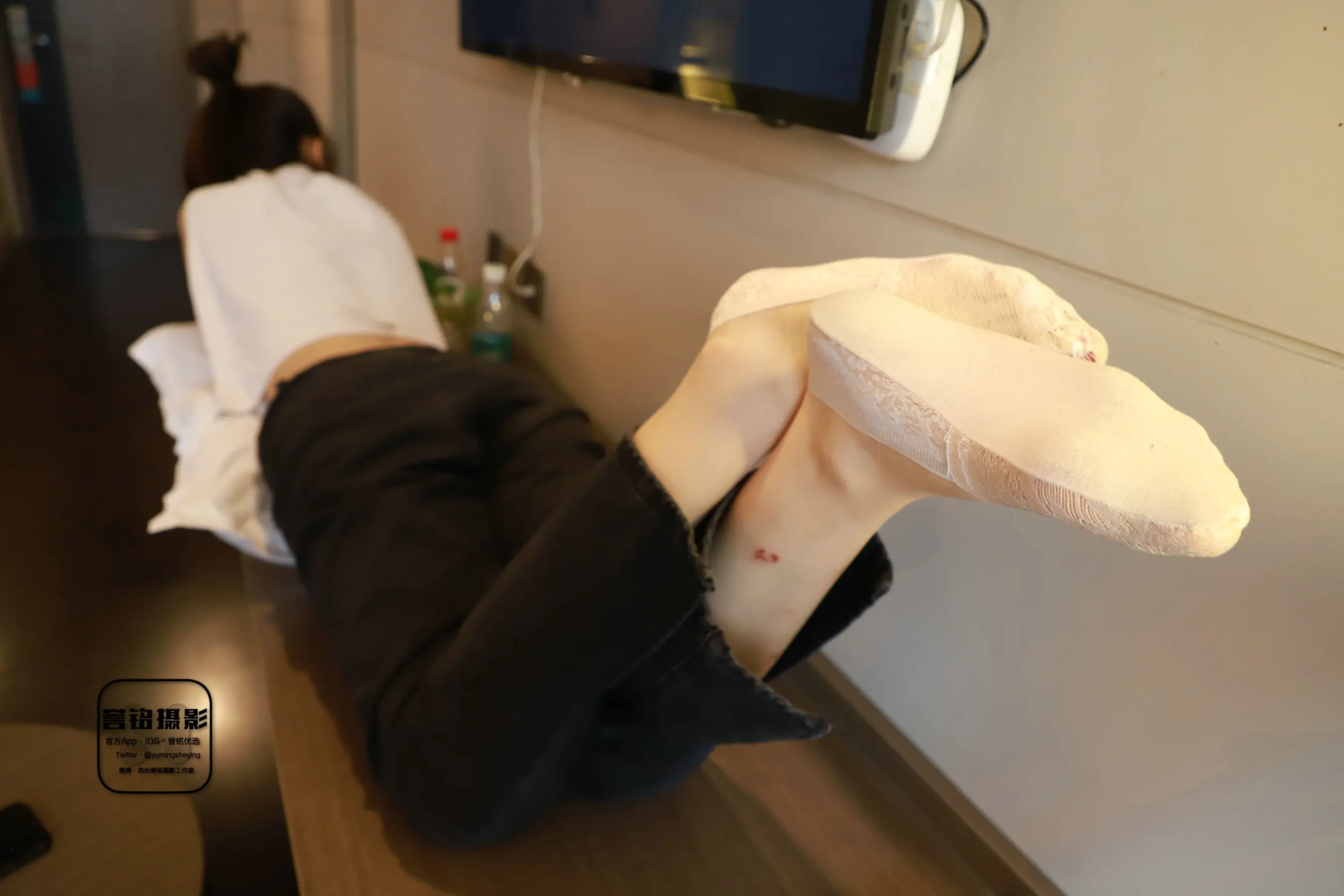 有一个女人躺在地板上，手里拿着一个大披萨