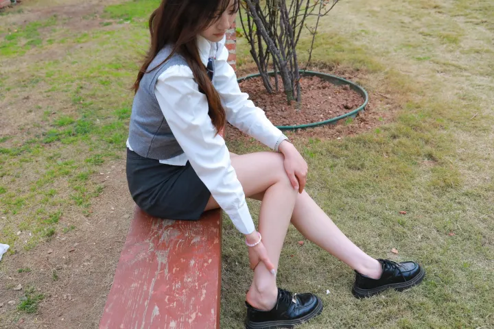 有个女人坐在长凳上，双腿交叉